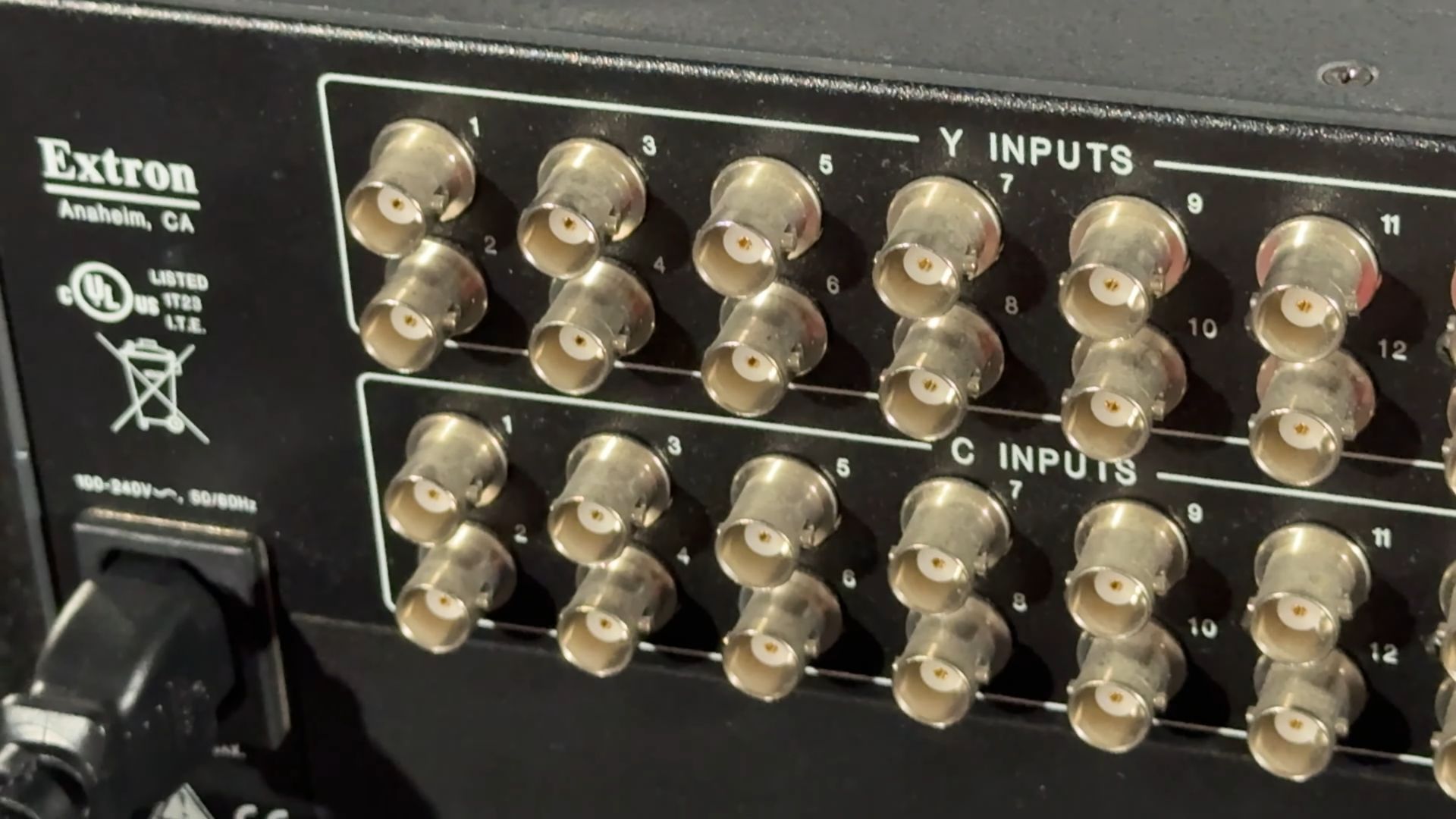 The rear of the Extron matrix switcher showing multiple BNC connectors for Y and C inputs, along with a power connector.